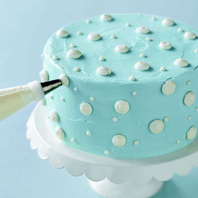 Til neatly piped dots, hold the pastry bag in both hands; keep the tip just above the cake's surface, at a slight angle. Gently squeeze out icing, release, and pull back. Frosting dots will also help to hide smudged edges or spotty icing; start with the large ones.
