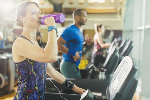 Kvinne on treadmill drinking water